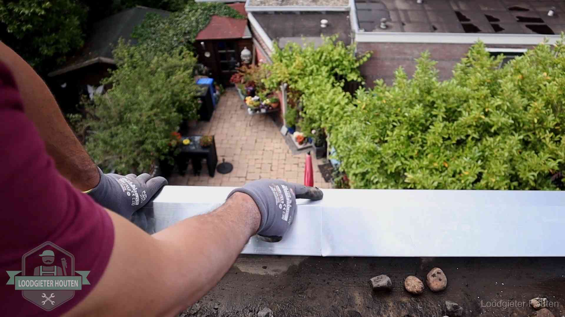 Daklekkage geregeld in Houten Vakman plaatst een daktrim op de dakrand van een woning in Houten