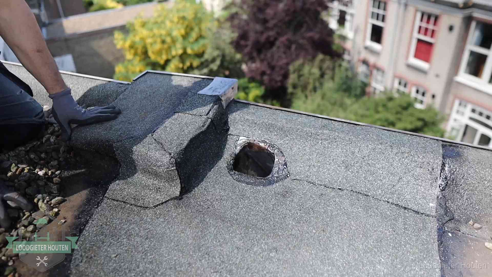 Daklekkage-inspectie op een plat dak in Houten Loodgieter inspecteert een beschadigd bitumen plat dak tijdens een daklekkage-inspectie in Houten