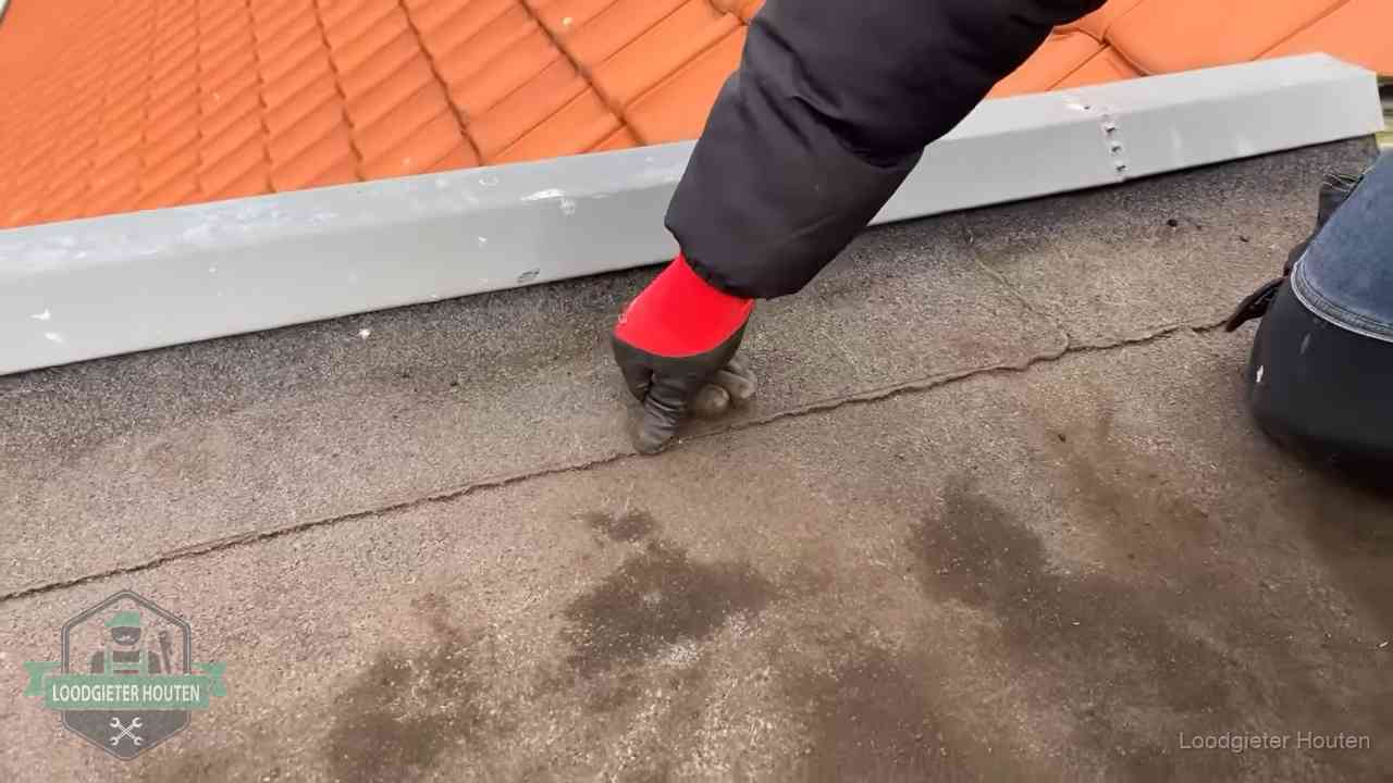 Lekkage bij de naad van een plat dak in Houten Vakman wijst een naad met vochtplekken aan op een bitumen plat dak in Houten
