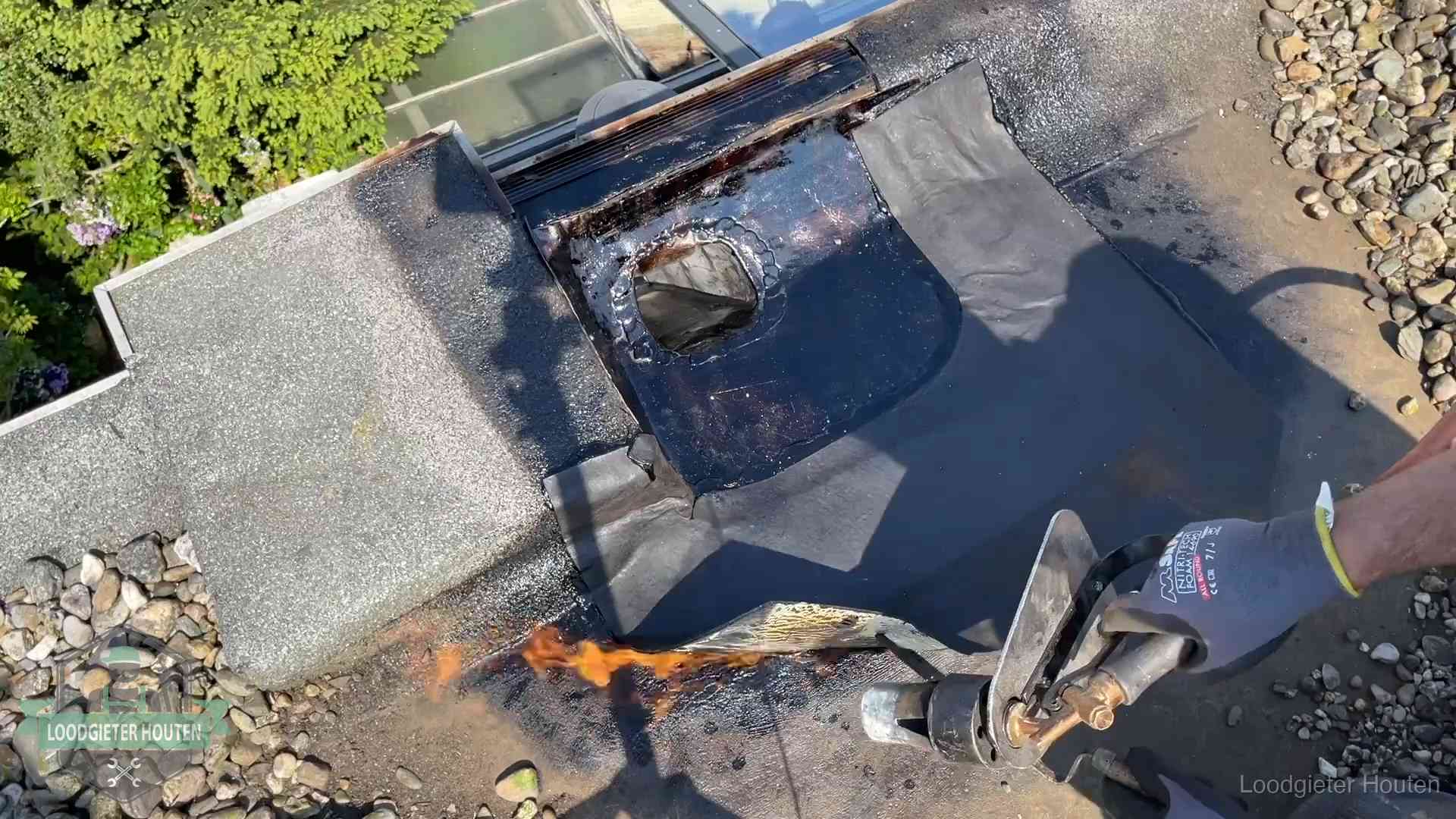 Daklekkage repareren in Houten Dakdekker brandt bitumen rond een doorvoer tijdens een daklekkage-reparatie in Houten