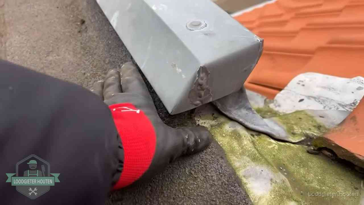Hemelwaterafvoer en dakgoot controleren in Houten Controle van een zinken hemelwaterafvoer met loodslab bij dakpannen in Houten