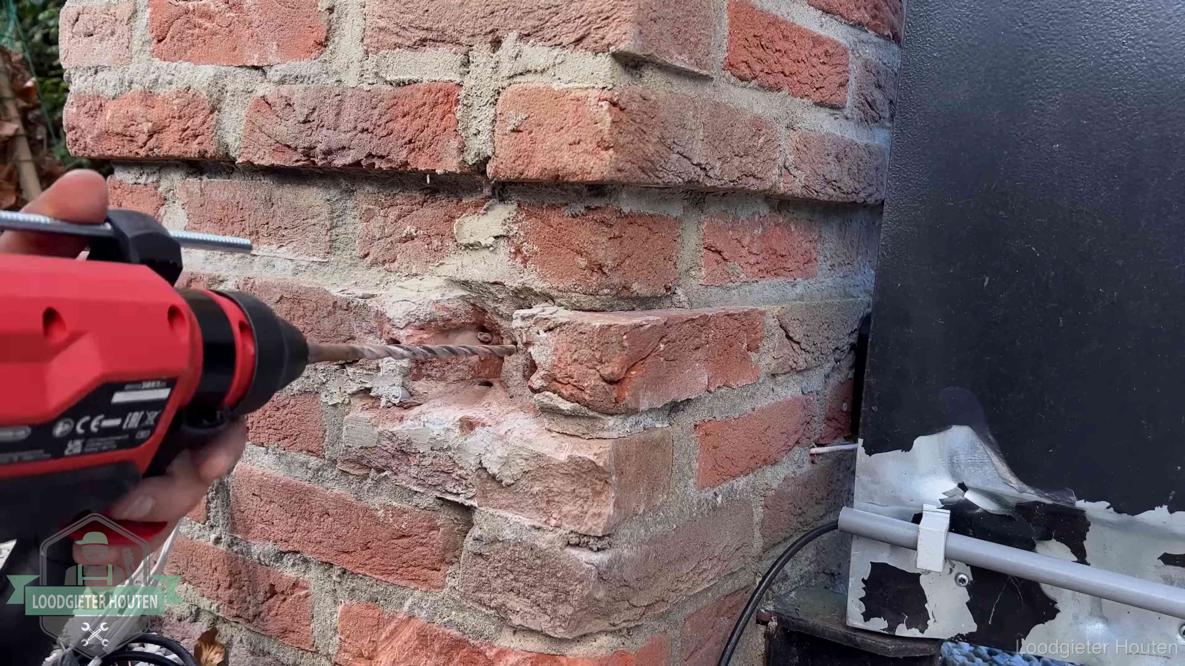 Vakman boort in de buitenmuur van een woning in de regio Houten