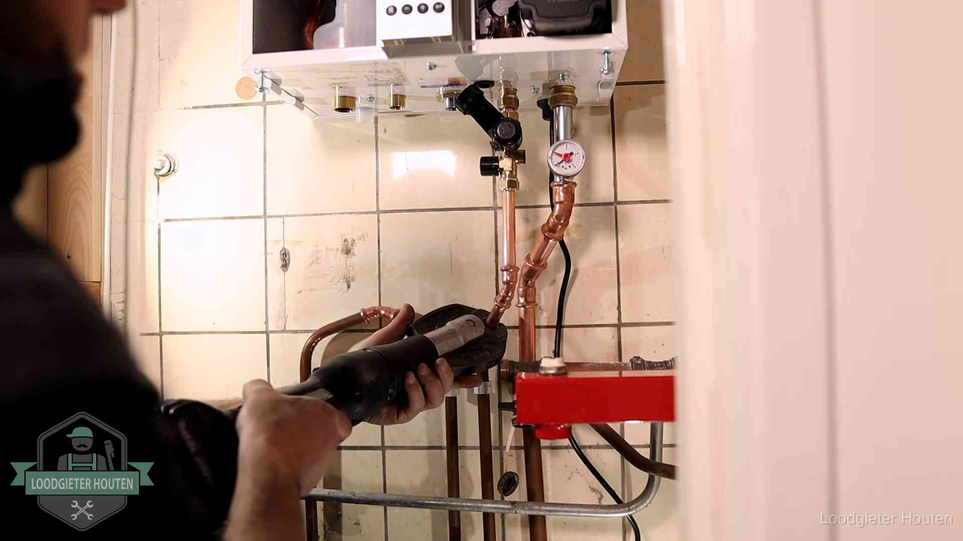 Monteur werkt aan de leidingen onder een cv-ketel in Houten