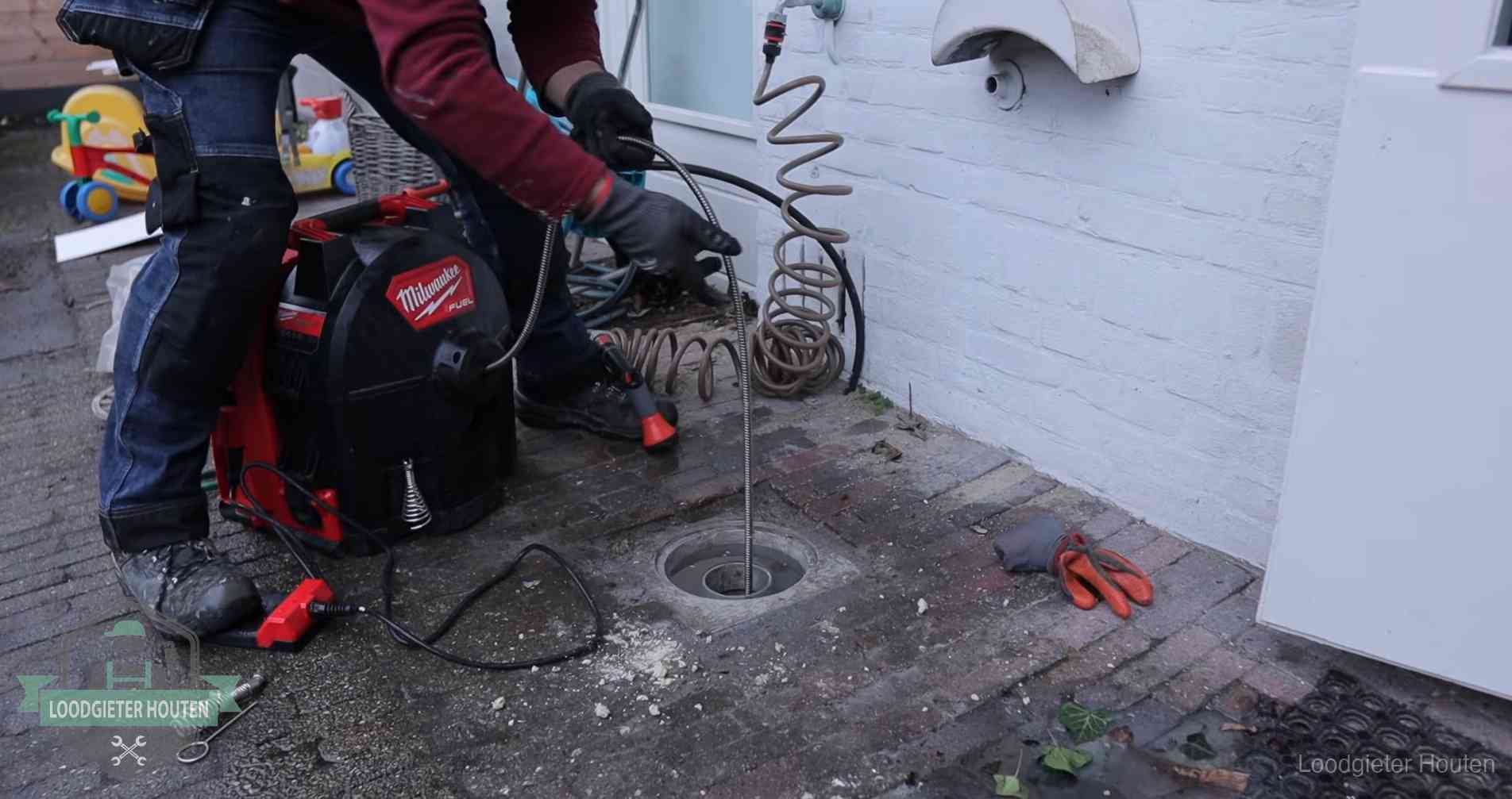 Erfgrens en gemeenteriool in Houten Ontstoppingsputje in de bestrating naast de gevel van een woning in Houten
