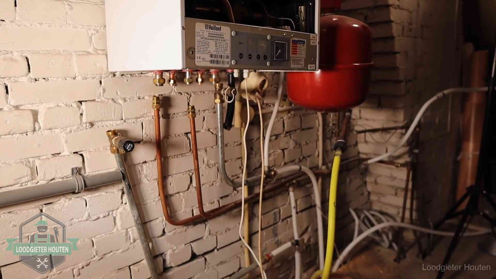 Verouderde cv-ketel met een wirwar van oude leidingen in een woning in Houten