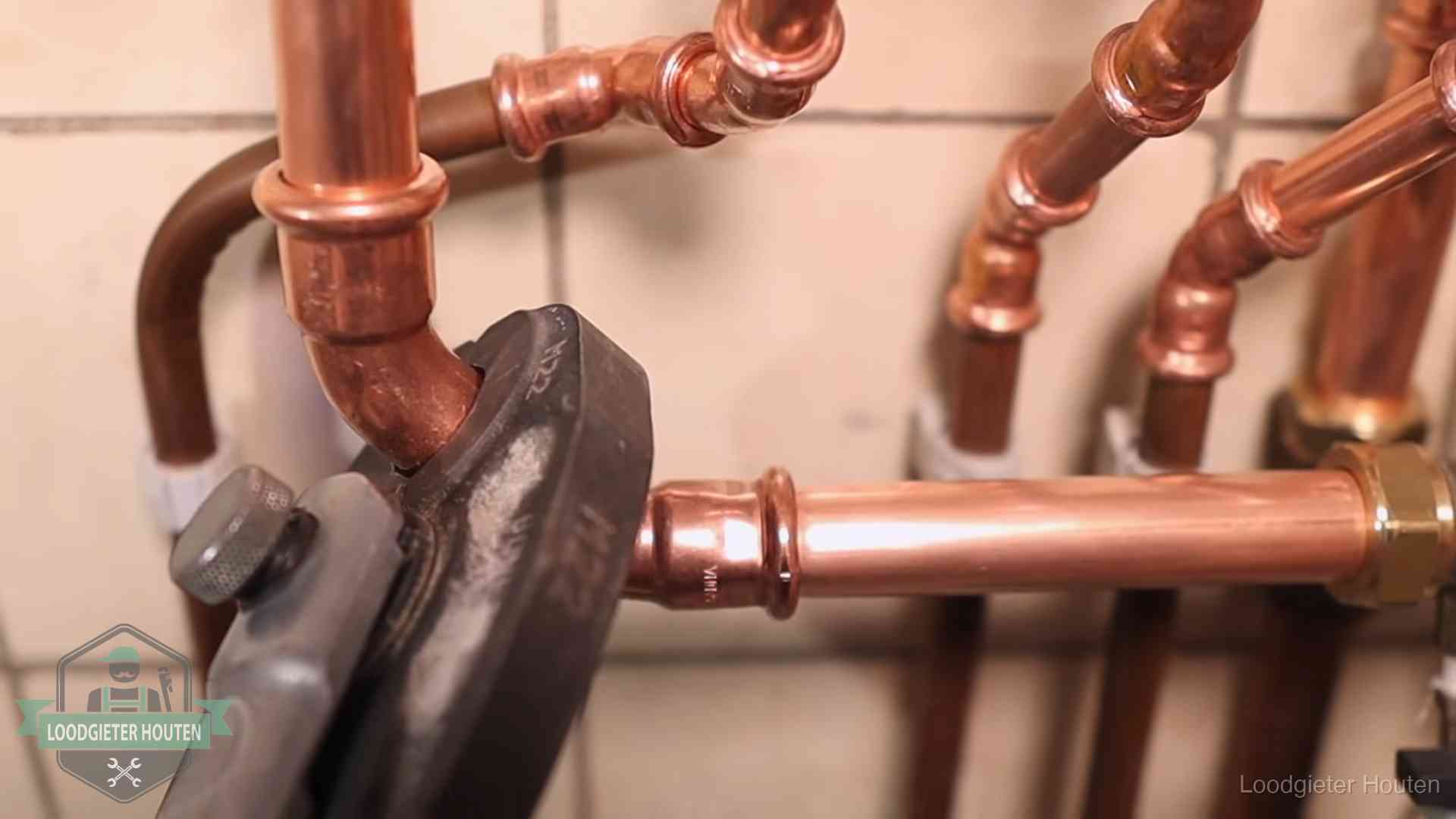Persmachine perst een koperen fitting op nieuw leidingwerk in Houten