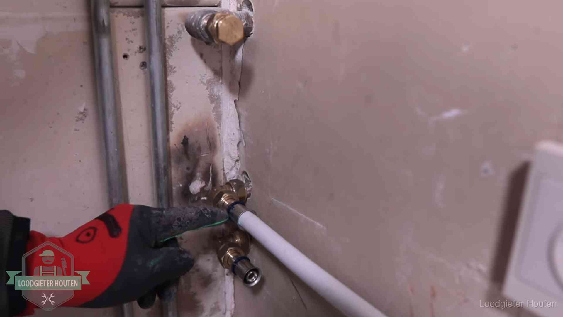 Loodgieter wijst de persfitting op nieuwe muuraansluitingen aan in een woning in Houten
