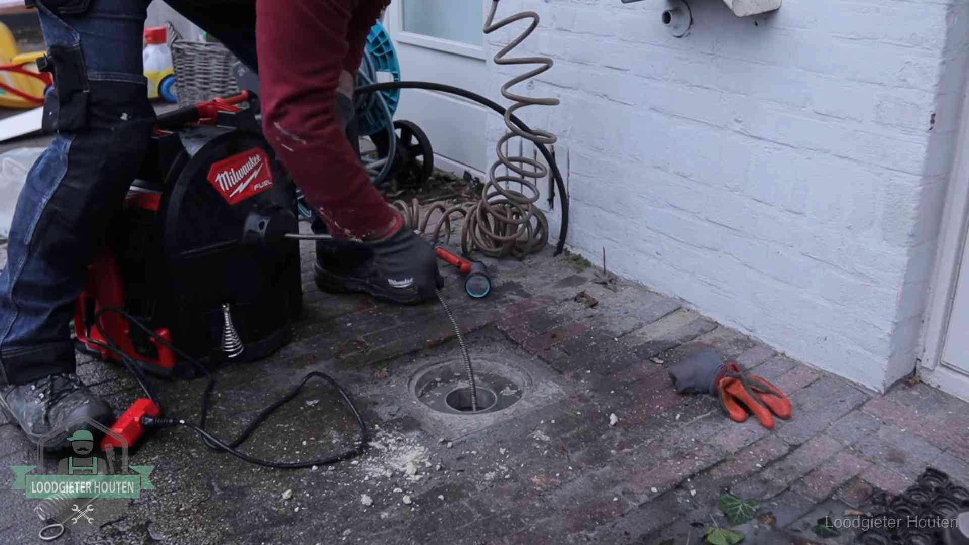 Prijs van een rioolontstopping in Houten Spiraalmachine bij een ontstoppingsputje in de bestrating in Houten