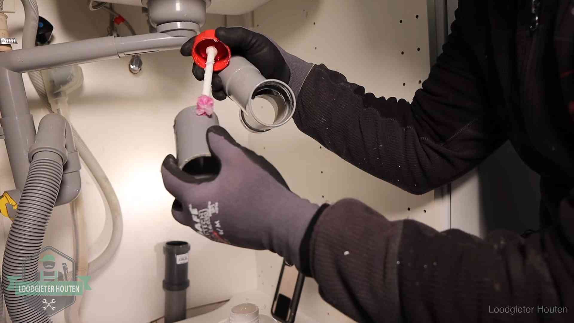 Oorzaak van een verstopte afvoer in Houten Loodgieter demonteert en reinigt de sifon onder een keukenkast in Houten