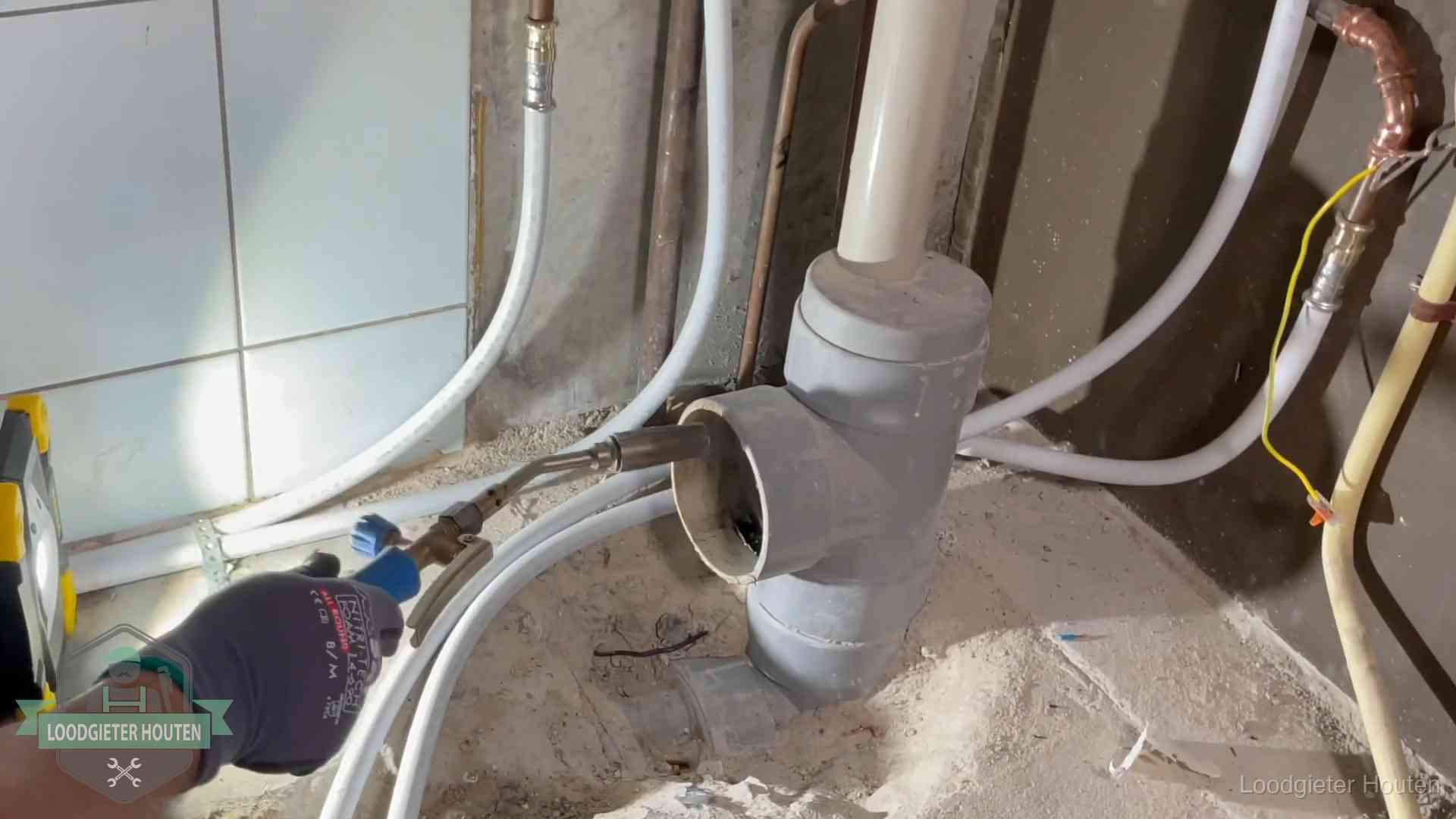 Verstopping in een huurwoning in Houten Loodgieter werkt aan leidingen bij de pvc-standleiding van een huurwoning in Houten