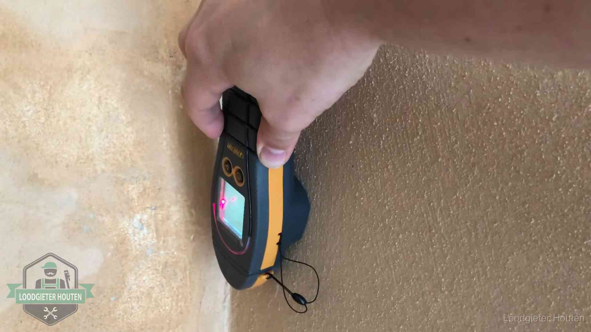 Daklekkage opsporen zonder hakwerk in Houten Vochtmeter tegen een muur met vochtplekken tijdens het opsporen van een daklekkage in Houten