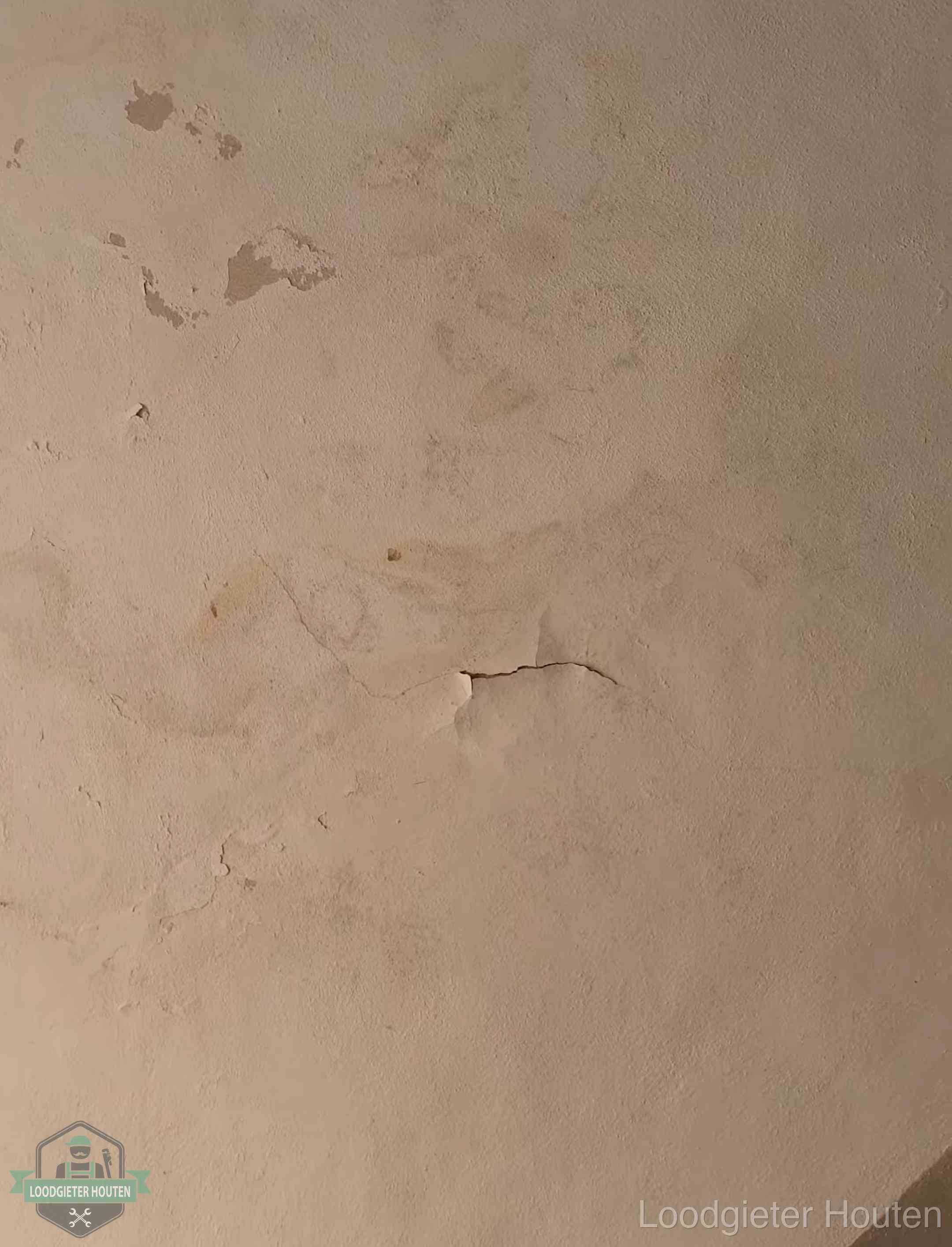Vochtkringen en afbladderende verf op een plafond in Houten, schade voor het meetrapport en de verzekering